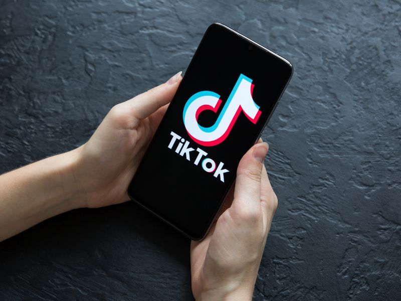 χέρι κρατάει κινητό με tik tok logo